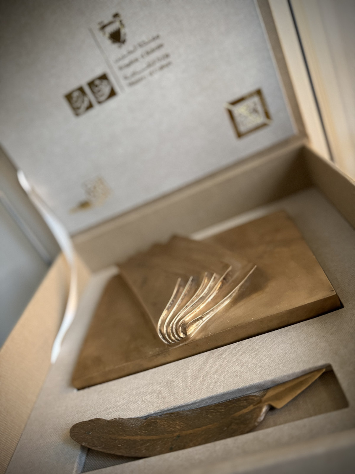 The Mohammed Al Banki Cultural Personality of the Year Award, a bronze open book and quill in its presentation case, awarded to Khalid Al Muharraqi by Bahrain’s Ministry of Culture in 2014